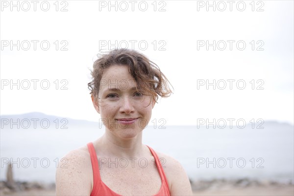 Caucasian woman smiling on rocky beach