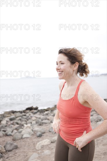 Caucasian woman standing on rocky beach