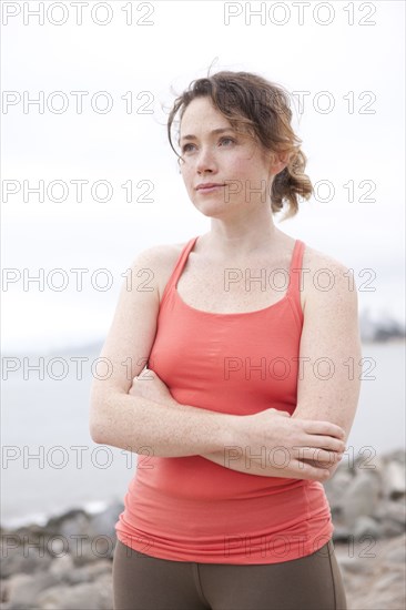 Caucasian woman standing on rocky beach