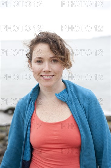 Caucasian woman smiling on rocky beach