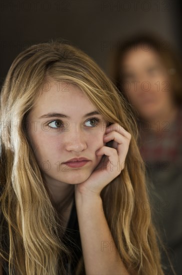 Serious teenage girl examining herself in mirror