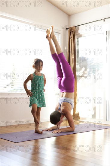 Mother and daughter practicing yoga in studio