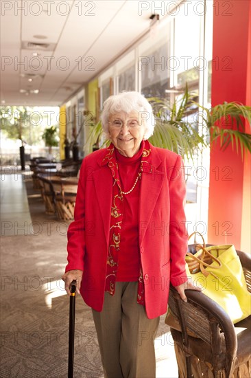 Older Caucasian walking with cane in retirement home