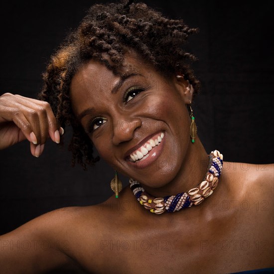 Close up of smiling woman wearing shell necklace