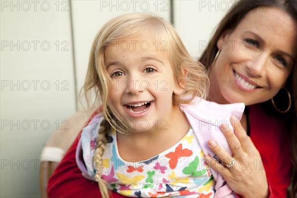 Caucasian mother and daughter smiling outdoors