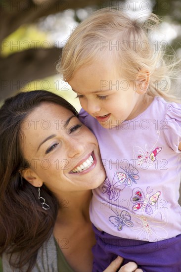 Caucasian mother and daughter smiling outdoors