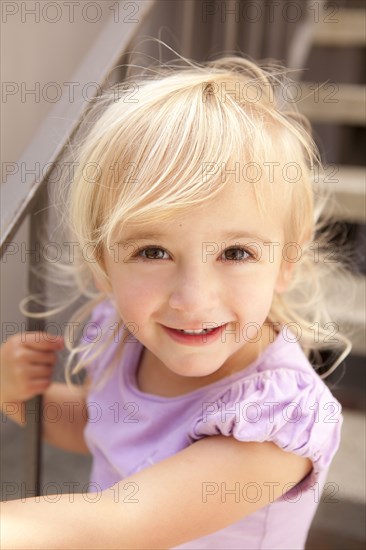 Smiling Caucasian girl sitting on steps