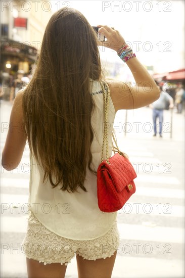 Rear view of woman taking photographs