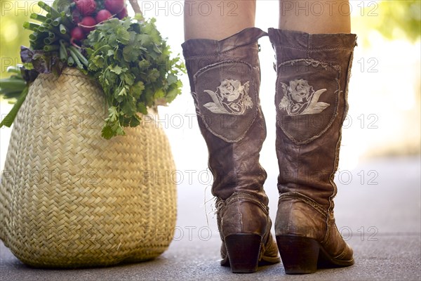 Close up of woman in boots with bag of produce