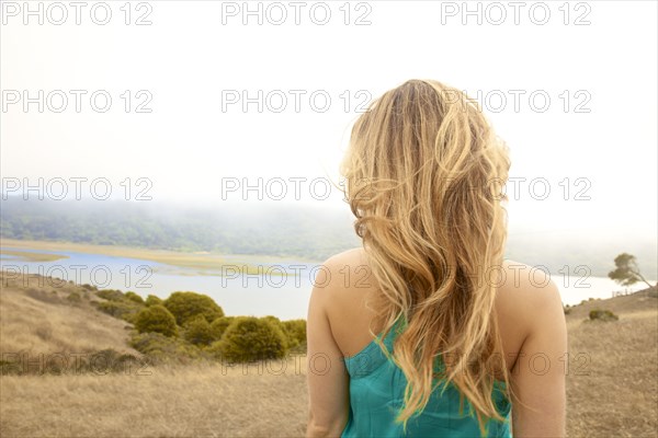 Rear view of woman admiring rural landscape from hilltop