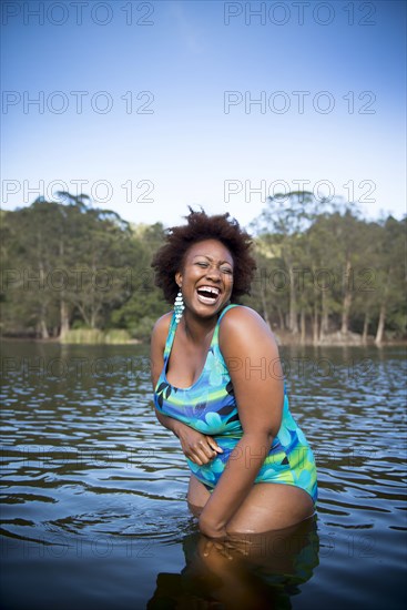 African American woman standing in rural lake