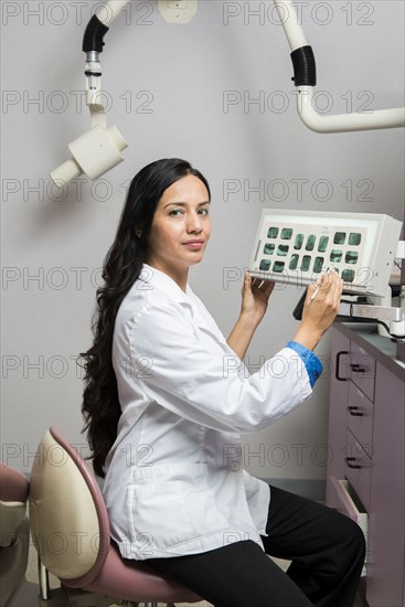 Indian dentist examining x-rays in office