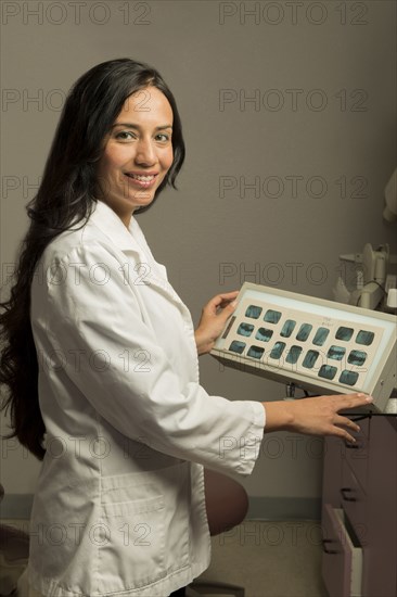 Indian dentist examining x-rays in office