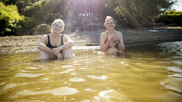 Older Caucasian women sitting in rural pond