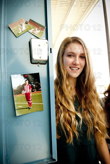 Student standing at decorated locker at high school