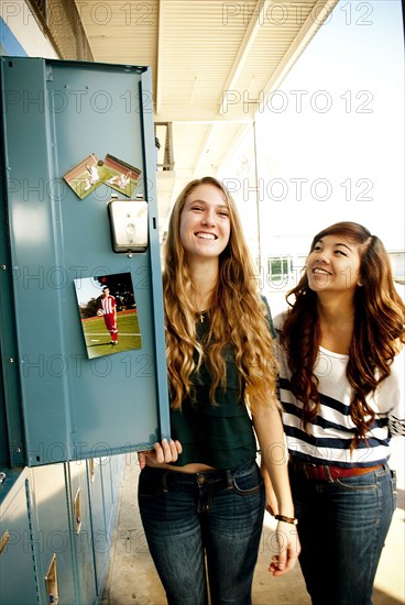 Students standing by decorated locker at high school