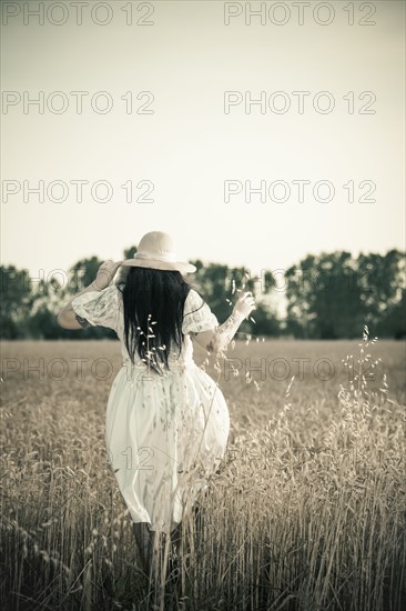 Woman walking in tall grass in rural field