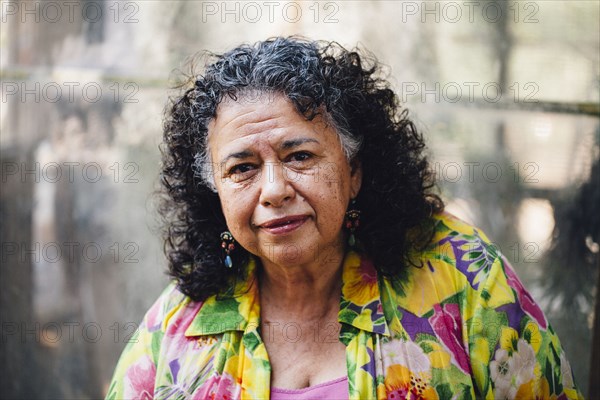 Hispanic woman smiling in smoky backyard