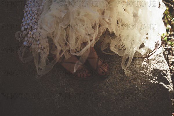 Close up of feet of bride wearing wedding gown and sandals
