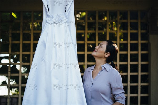 Korean bride admiring wedding dress