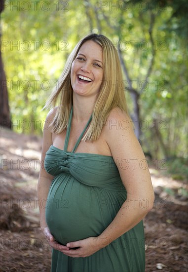 Laughing pregnant woman holding belly