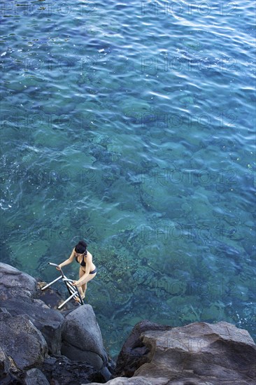 High angle view of woman climbing ladder out of ocean