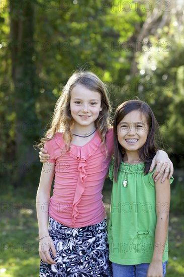 Smiling girls hugging in backyard