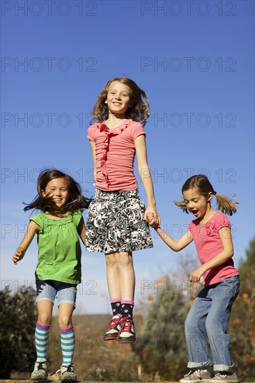 Girls jumping for joy on wall