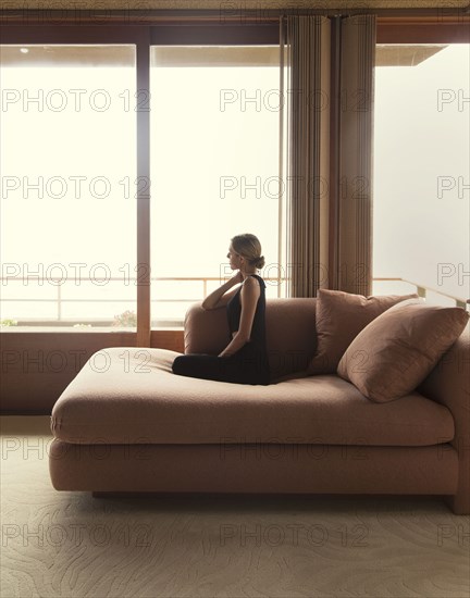 Woman sitting on sofa in modern living room