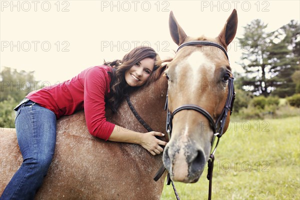 Woman riding horse in rural field