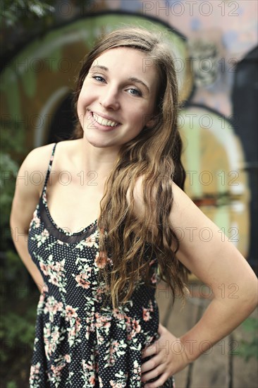 Smiling woman standing near graffiti wall