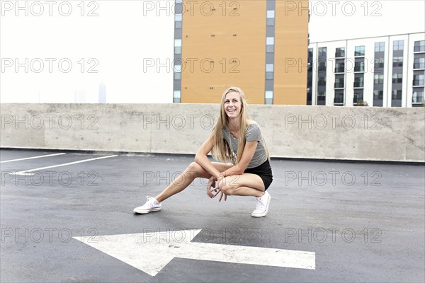 Teenage girl posing on urban rooftop parking lot