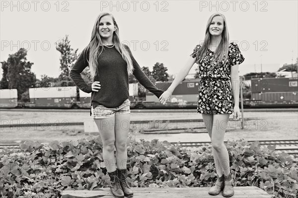 Teenage girls holding hands in train yard