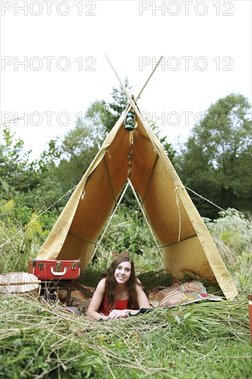 Woman laying in camping tent in field