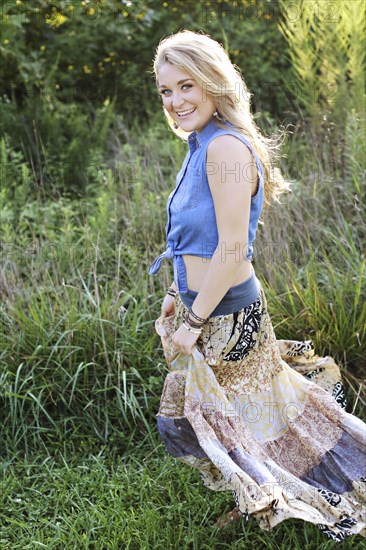 Teenage girl walking in tall grass