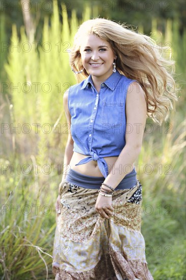 Teenage girl walking in tall grass