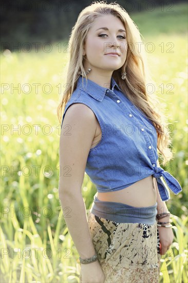 Teenage girl standing in tall grass