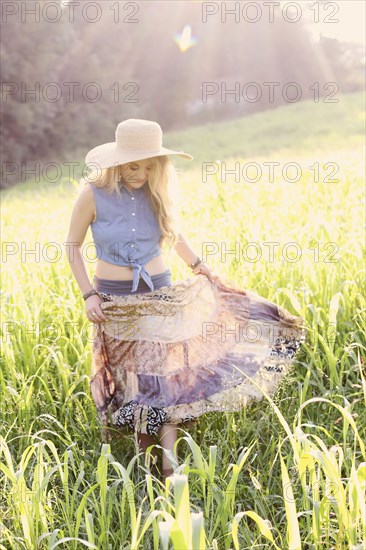 Teenage girl walking in tall grass