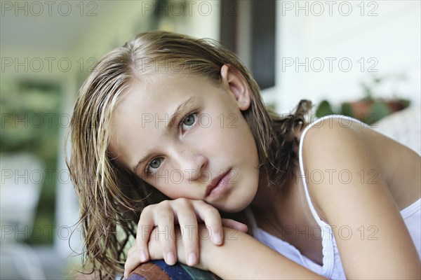 Close up of serious girl leaning in armchair