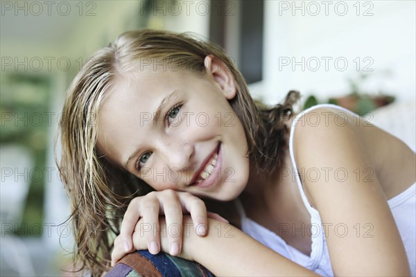 Close up of smiling girl leaning in armchair