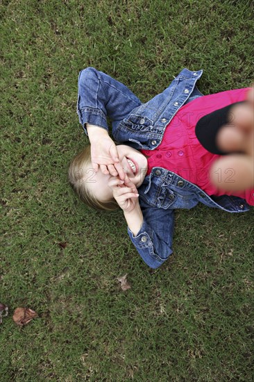 High angle view of girl laying in grass