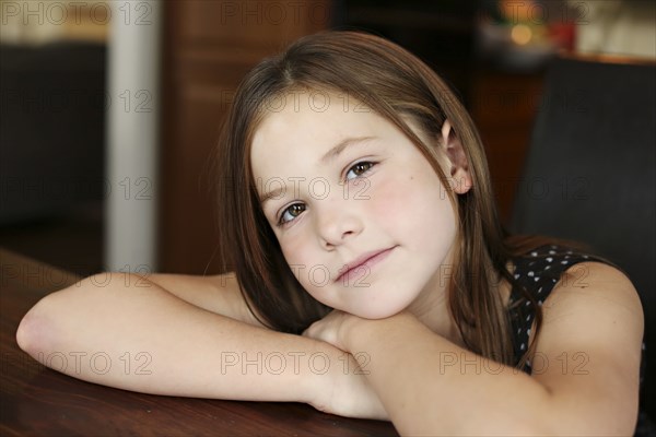 Close up of serious girl resting chin on hand