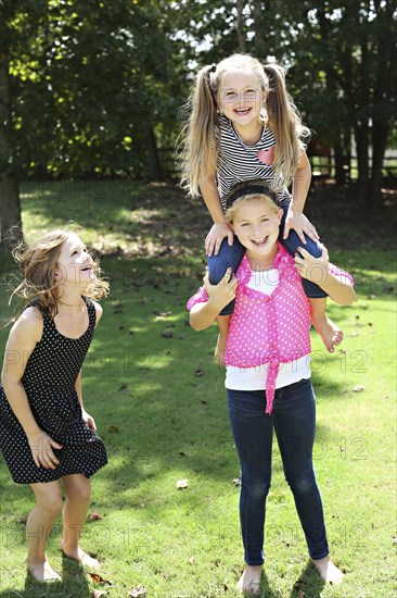 Smiling girls playing in rural field