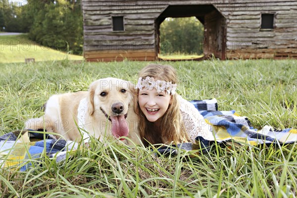 Caucasian girl laying on blanket with dog