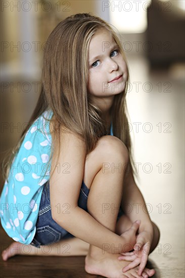 Serious girl sitting on floor