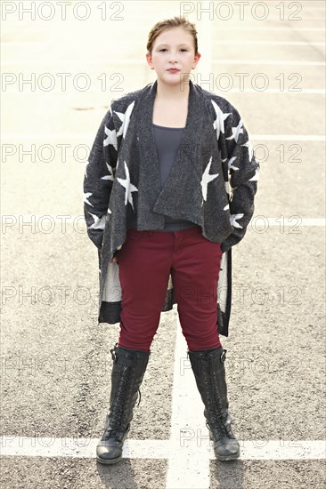 Stylish Caucasian girl standing in parking lot