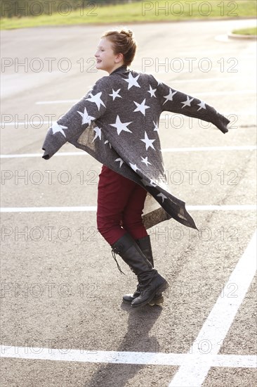 Stylish Caucasian girl walking in parking lot