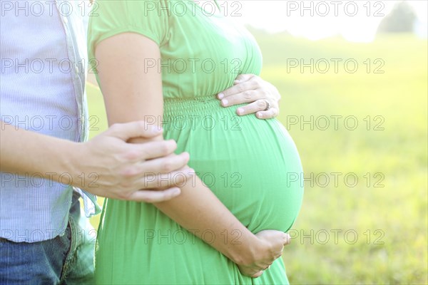 Close up of Caucasian man hugging pregnant wife