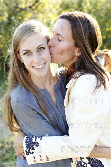 Close up of mother kissing cheek of daughter
