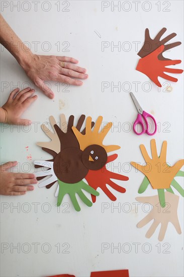 Students and teacher making Thanksgiving turkey crafts in classroom